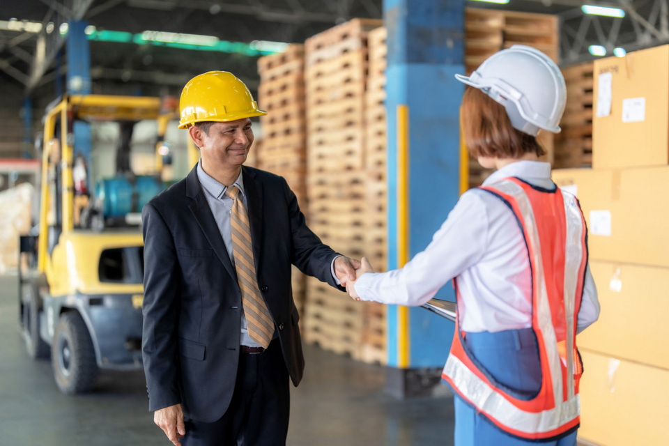 A handshake between a supplier and a buyer in a factory