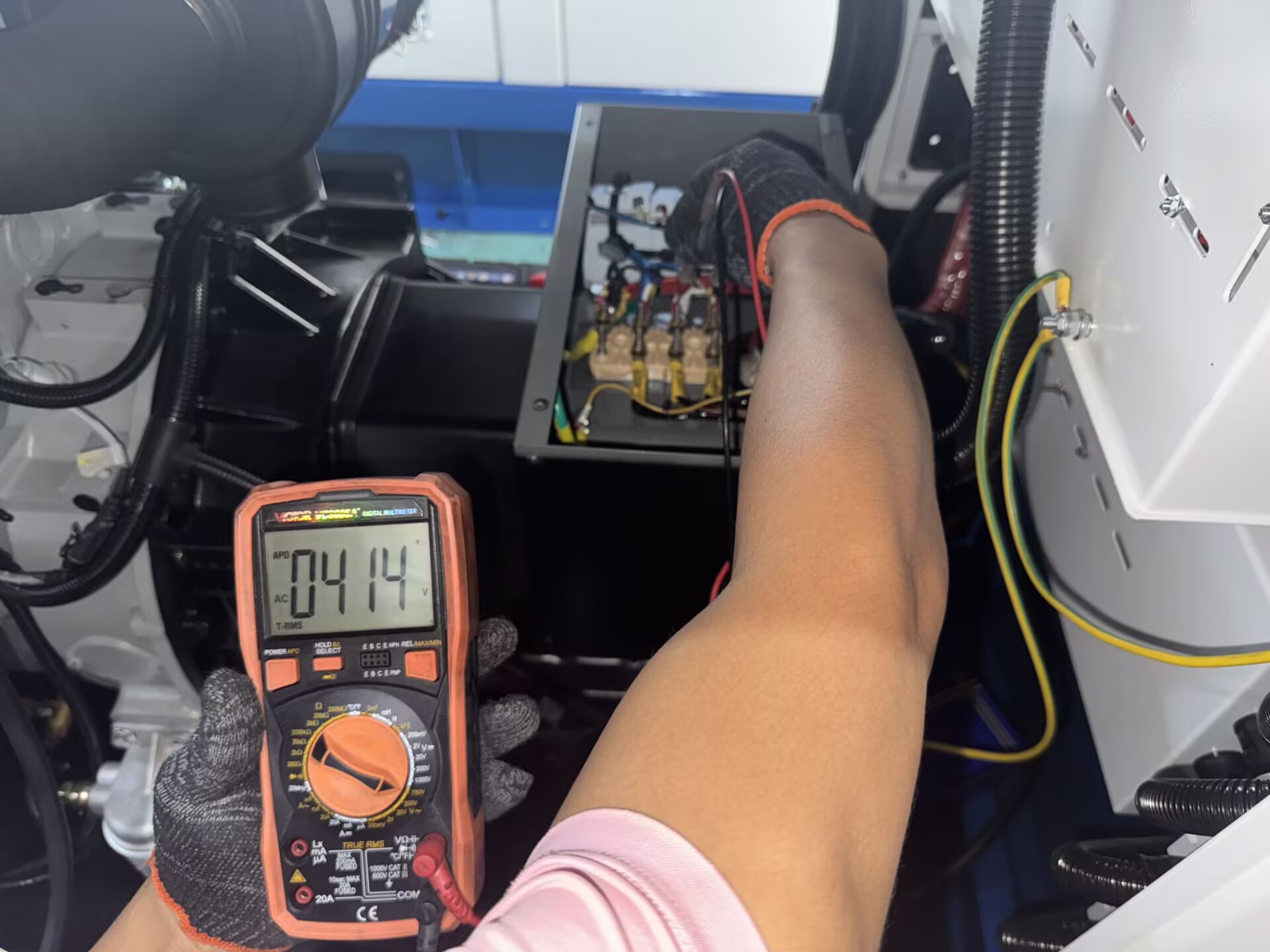 Technician checking an alternator with a multimeter for voltage issues