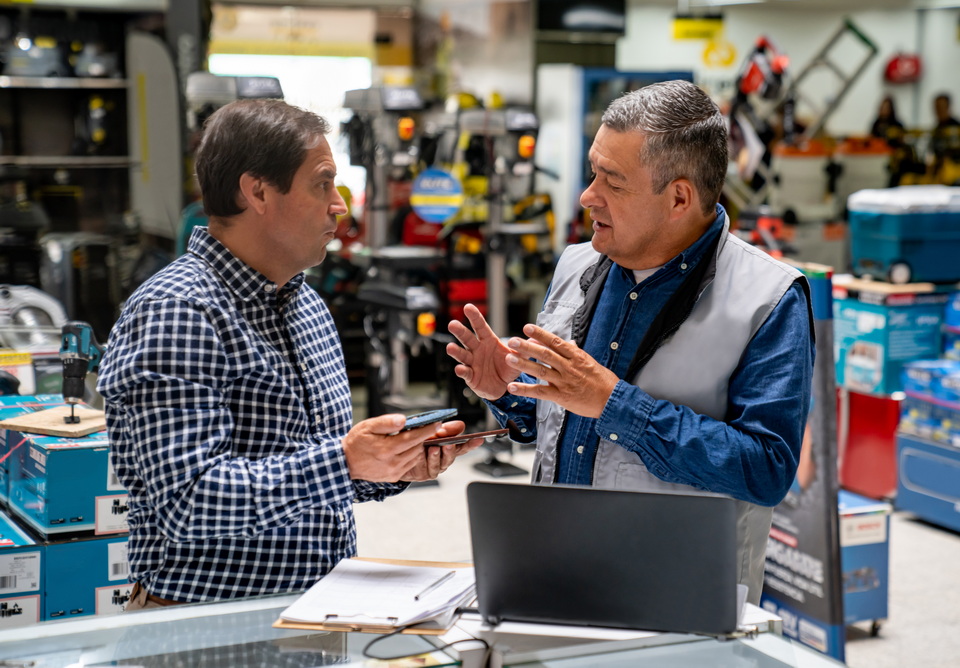A project manager discussing alternator options with a supplier in a workshop